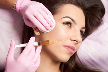 beautiful woman getting injection in the cosmetology salon